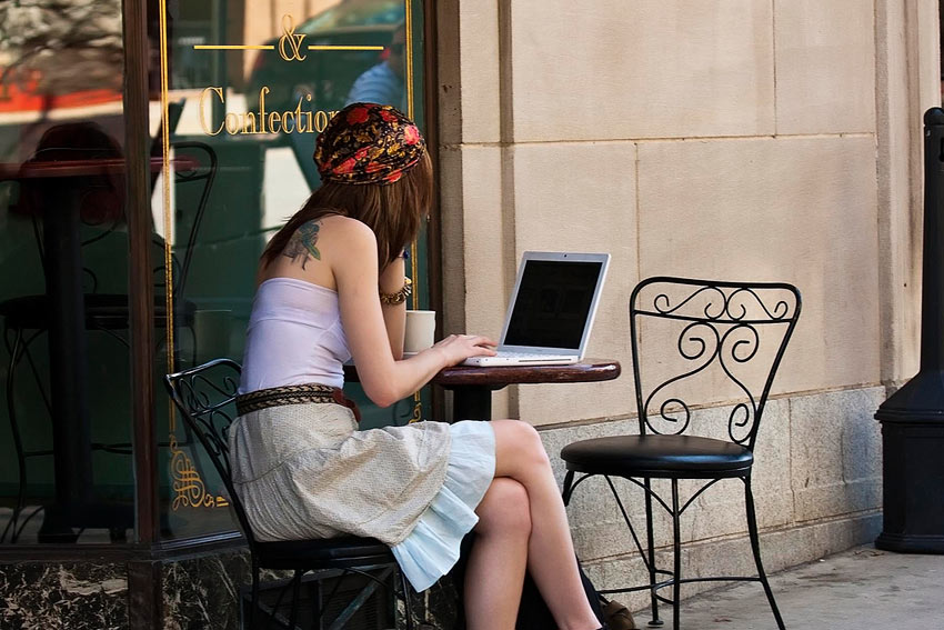 A young self-employed woman is working with laptop in a cafe