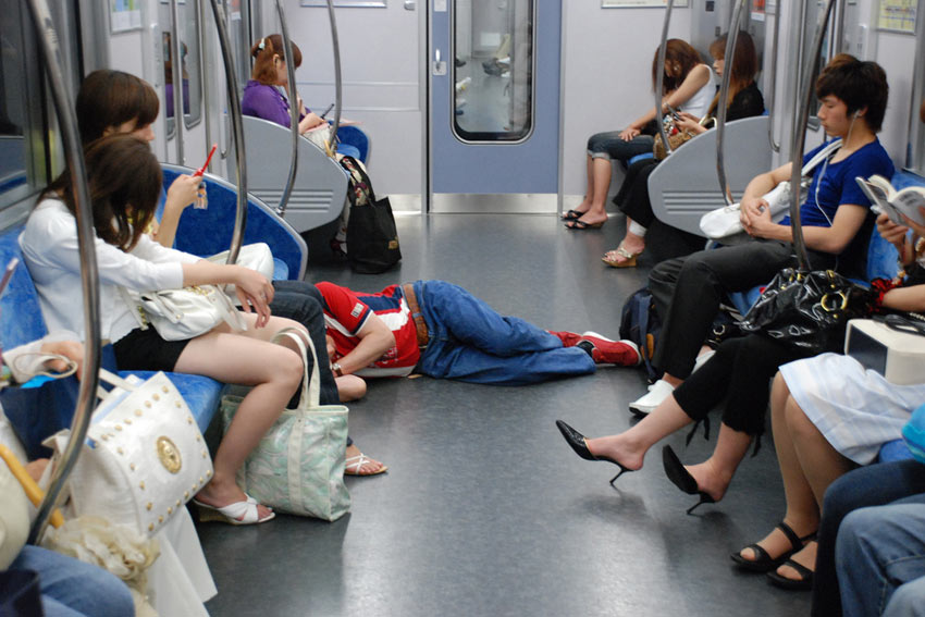 A drunk person sleeping on a train