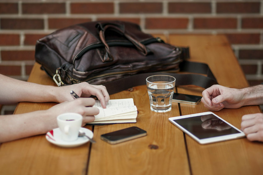 Old and new: Pen-and-paper and gadgets in a business meeting