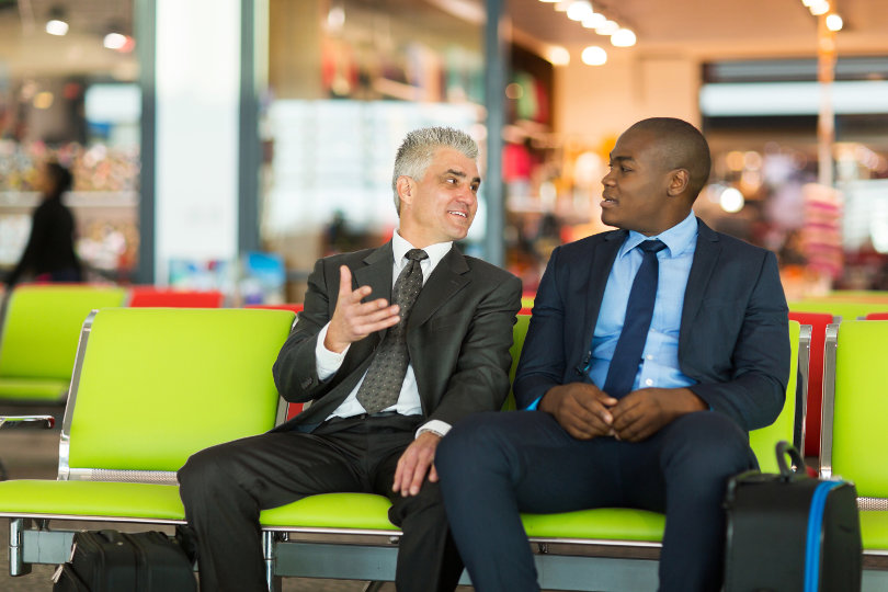 Businessmen talk during airport layover
