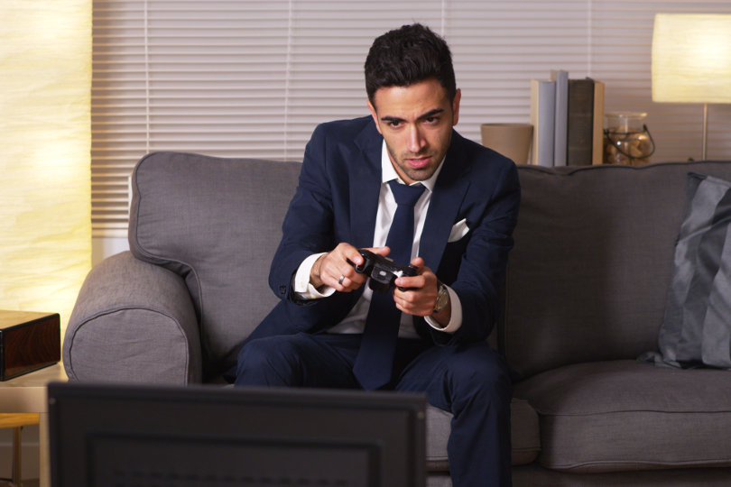 Procrastinating businessman playing video games