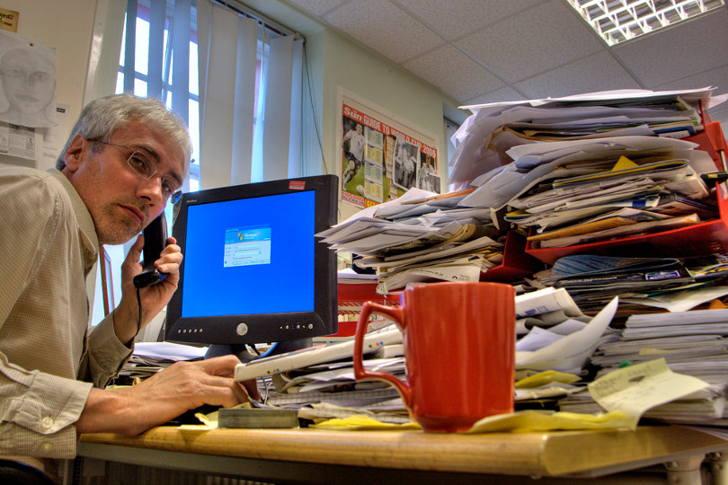 Busy businessman with cluttered desk
