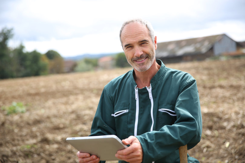 Modern farmer using tablet PC in the field