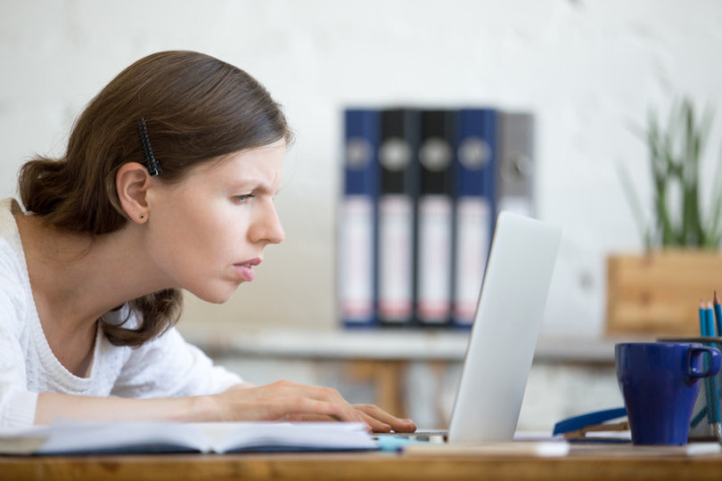Squinting business woman looking at a badly-designed website